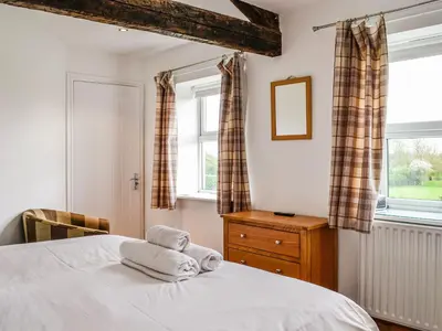 a bedroom with a bed with towels on it at Mount Farm - The Stable in Harker