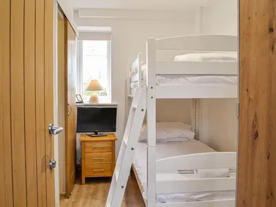 a bedroom with a bunk bed and a desk at Mount Farm - The Stable in Harker