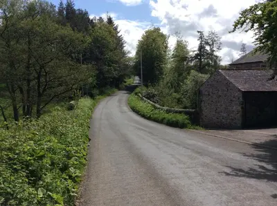 a dirt road with a building on the side at Lake District Western 2-Bed Cabin Pet Friendly in Wigton
