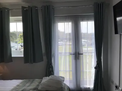 a bedroom with a bed and a large window at Beachcomber in Garlieston