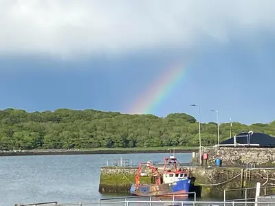 a boat is docked at a dock in the water at Beachcomber in Garlieston