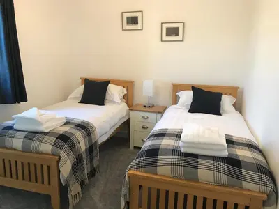 two beds sitting next to each other in a room at Beachcomber in Garlieston