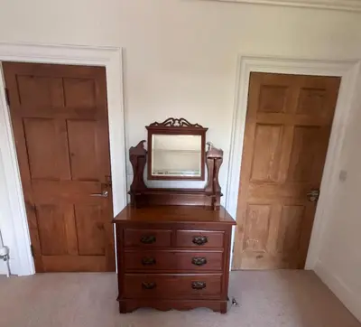 a mirror on top of a dresser with two doors at Holiday House at 22, 3 bedroom cottage in historic Wigtown in Wigtown