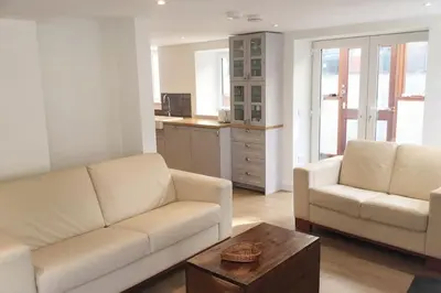 a living room with two white couches and a coffee table at Holiday House at 22, 3 bedroom cottage in historic Wigtown in Wigtown