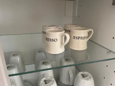 a glass shelf with cups and other appliances on it at Holiday House at 22, 3 bedroom cottage in historic Wigtown in Wigtown