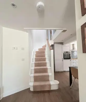 a staircase in a living room with a stair case at Holiday House at 22, 3 bedroom cottage in historic Wigtown in Wigtown