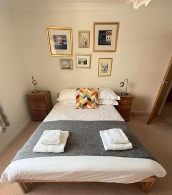 a bedroom with a large bed with two towels on it at Holiday House at 22, 3 bedroom cottage in historic Wigtown in Wigtown