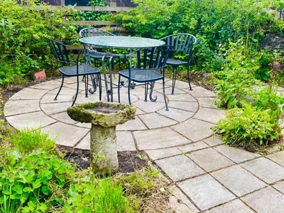 a table and chairs sitting on a stone patio at Rosebank Cottage in Borgue
