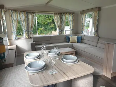 a living room with a table and a couch at Coral Cabin in Kippford