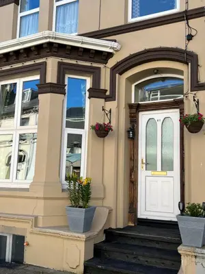 a house with a white door and potted plants at Sea-Renity - Self Catering Holiday Let in Douglas