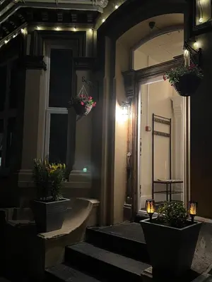 a hallway with stairs with potted plants and a mirror at Sea-Renity - Self Catering Holiday Let in Douglas