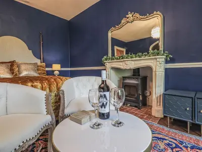 a room with a bed and two glasses of wine at Wisteria in Ambleside