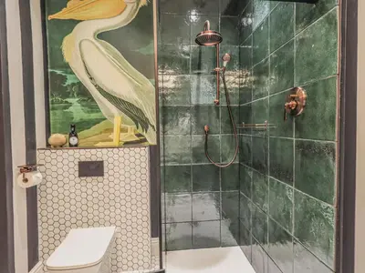 a bathroom with a shower with a peacock painting on the wall at Wisteria in Ambleside