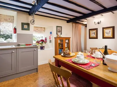 a kitchen with a wooden table with chairs and a dining room at Stone Beck in Ambleside