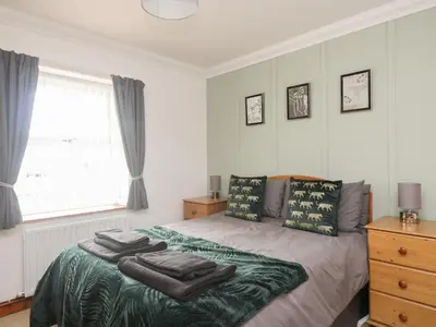 a bedroom with a bed with towels on it at Shoreside Cottage in Wigton