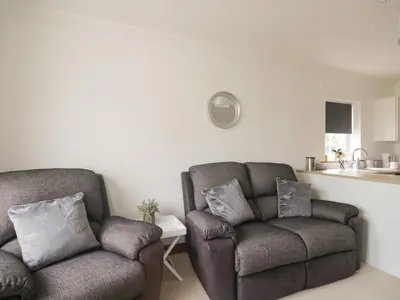 a living room with two chairs and a table at Shoreside Cottage in Wigton