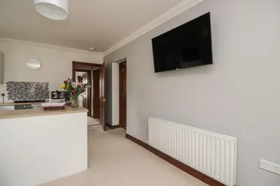 a living room with a flat screen tv on the wall at Shoreside Cottage in Wigton
