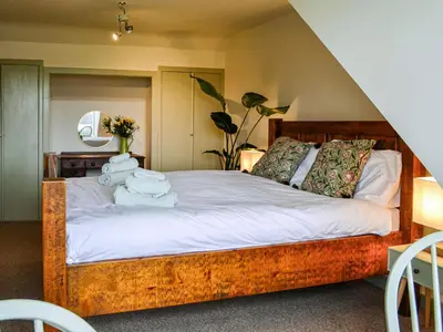 a bedroom with a wooden bed with towels on it at 9A Church Place in Kirkcudbright