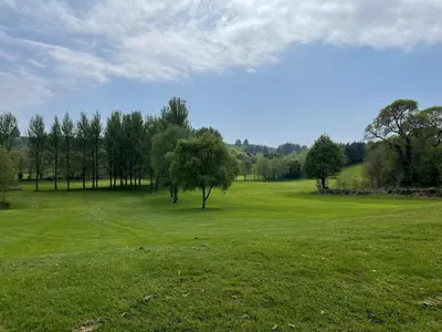 a green field with trees in the middle of it at Beautiful 3BR Lodge - Stunning Beach and Golf Location - Pass the Keys in Dalbeattie
