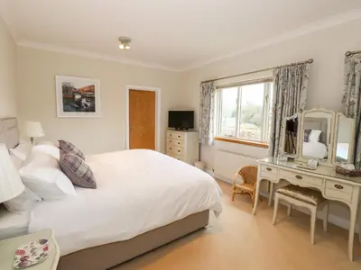 a bedroom with a bed and a desk and a mirror at Edencroft in Penrith