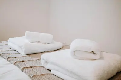 a pile of towels sitting on top of a bed at The Bailey - Troon - Coorie Doon Stays in Troon