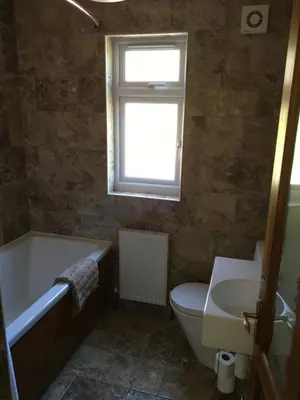 a bathroom with a tub and a toilet and a window at Gamepark Wood Holiday Cottage in Castle Douglas