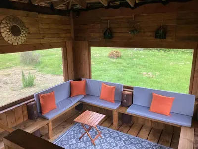a blue couch with orange pillows on a porch at Gamepark Wood Holiday Cottage in Castle Douglas
