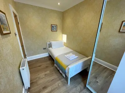 a small bedroom with a bed and a shower at Beautifully Presented 3BR Luxury Apartment - Pass the Keys in Kirkcudbright