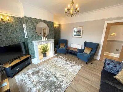 a living room with blue chairs and a fireplace at Beautifully Presented 3BR Luxury Apartment - Pass the Keys in Kirkcudbright