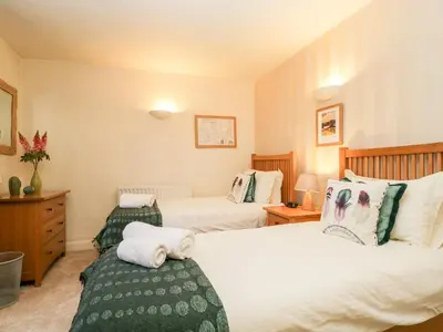 two beds in a hotel room with two beds at Raphael's Cottage in Keswick