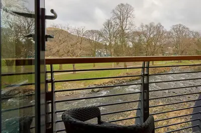 a chair sitting in front of a window looking at a train at Riverside Park 6 in Keswick