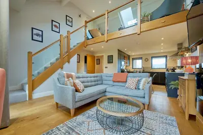 a living room with a couch and a staircase at Riverside Park 6 in Keswick