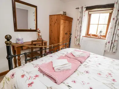 a bedroom with a bed with towels on it at Lavender Cottage in Penrith