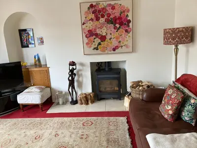 a living room with a couch and a fire place at Rose Cottage in Prestwick