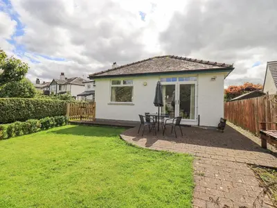 a patio with a table and chairs in a yard at Limhus Cottage in Keswick