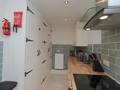 a kitchen with white cabinets and a counter top at Lucys cottage in Canonbie