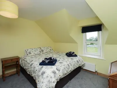 a bedroom with a bed with two bags on it at Lucys cottage in Canonbie