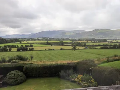 a view of a green field with mountains in the background at Squirrel Cottage in Keswick