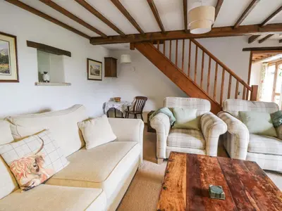 a living room with two couches and a table at Daisy Cottage in Penrith