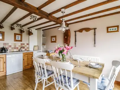 a kitchen and dining room with a wooden table and chairs at Daisy Cottage in Penrith