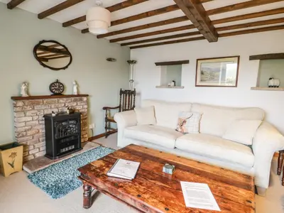 a living room with a couch and a fireplace at Daisy Cottage in Penrith