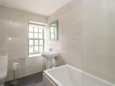 a white bathroom with a sink and a bath tub at 2 Fleet Street in Castle Douglas