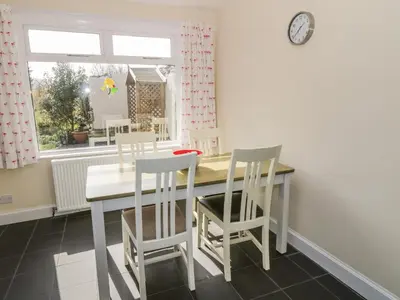 a dining room with a table and chairs and a window at 7 Cummertrees in Annan