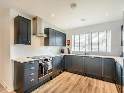 a kitchen with black cabinets and a sink at Oystercatcher in Drummore