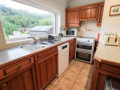 a kitchen with a sink and a stove and a window at 7 Stybarrow Terrace in Penrith