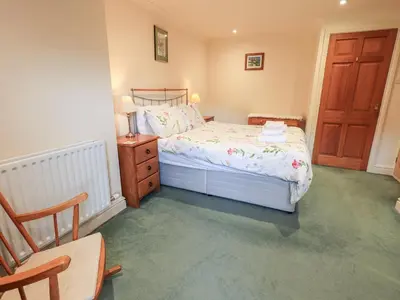 a small bedroom with a bed and a wooden door at 7 Stybarrow Terrace in Penrith