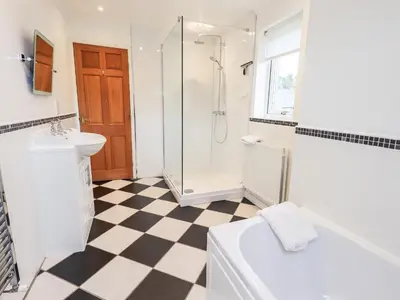 a bathroom with a shower and a toilet and a sink at 7 Stybarrow Terrace in Penrith