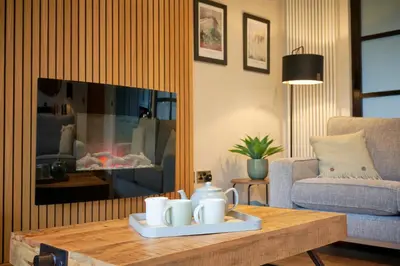 a living room with a coffee table and a fireplace at Riverside Park 3 in Keswick