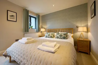 a bedroom with a large bed with towels on it at Riverside Park 3 in Keswick