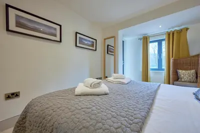 a bedroom with a large bed with towels on it at Riverside Park 2 in Keswick